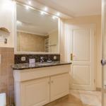 Bathroom with sink, mirror, shower, and toilet.