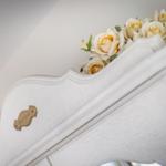 Weißer Schrank mit Blumen und goldenem Schild