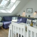 Living and dining area with sofa, chair, and skylight.