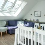 Living space with sloped ceiling, skylight, sofa and chair