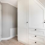 Schlafzimmer mit weißem Schrank und Holzboden
