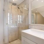 Dusche mit Glaswand, Waschbecken und Spiegel