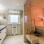 Badezimmer mit Sauna, Waschbecken und Fenster