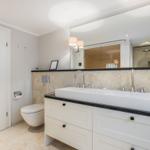 Badezimmer mit Waschtisch, Spiegel und Dusche