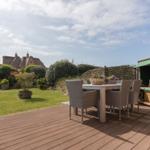 Terrasse mit Esstisch, Garten und Blick auf traditionelle Häuser.