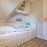 Schlafzimmer mit Doppelbett, Schränken und Holzboden.