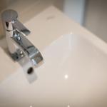 Moderne Waschbecken mit chromfarbenem Wasserhahn und glatter Oberfläche.