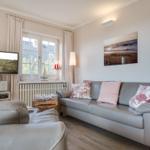 Wohnzimmer mit Sofa, Fernseher und Fenster mit Blick.