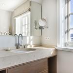 Bathroom with sink, mirror, and window with view.