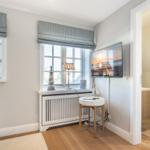 Room with window, TV, and view into the toilet