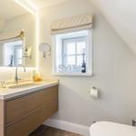 Bathroom with sink, mirror, and window.