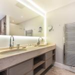 Bathroom with double sink, mirror cabinet, and heated towel rail.