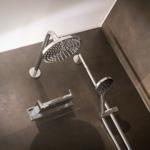 Shower with shower head and handheld shower on dark floor