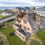 House with thatched roof and terrace by the coast