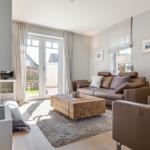 Wohnzimmer mit Sofa, Kamin und Terrassentür.