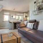 Living and dining area with sofa, table, and kitchenette.