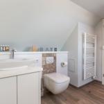 Bathroom with sink, toilet, and radiator.