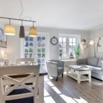 Essbereich mit Tisch und Stühlen, Wohnzimmer mit Sofa und Couchtisch.