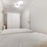Schlafzimmer mit Doppelbett, Kleiderschrank und Lampe.