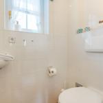 Badezimmer mit Toilette, Waschbecken und Fenster