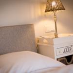 Schlafzimmer mit Bett, Nachttisch und Lampe