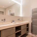 Badezimmer mit Doppelwaschbecken, Spiegel und Heizkörper