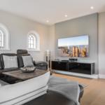 Wohnzimmer mit Sofa, Fernseher und Kamin