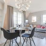 Dining area with table and chairs. Living area with sofa and windows.
