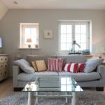 Living room with sofa, glass table, and windows