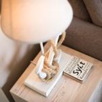 Lamp with rope on wooden table next to sofa