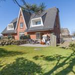 Rotes Backsteinhaus mit Terrasse und Garten. Grillplatz und Strandkorb vorhanden.