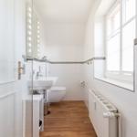 Badezimmer mit Waschbecken, Toilette und Fenster