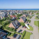 Haus mit Garten und Parkplatz in Küstenort mit Blick auf Meer.