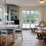 Wohn- und Essbereich mit Sitzgruppe, Esstisch und Glasfront zur Terrasse.