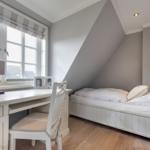 Schlafzimmer mit Dachschräge, Schreibtisch und Bett