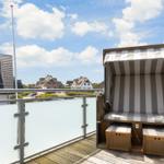Terrace with beach chair and view of residential houses.