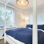 Bedroom with bed, window, and ceiling light.