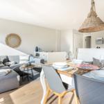 Living and dining area with sofa, table, and pendant lamp.