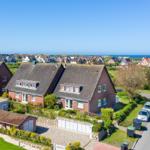 Red brick house with dormers and garden. View of beach and sea.