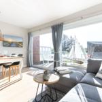 Living and dining area with view of the garden and sailboat.