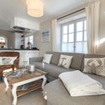 Wohnzimmer mit Sofa, Couchtisch und Küchenbereich im Hintergrund.