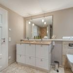 Badezimmer mit Waschbecken, Spiegel und Toilette
