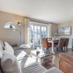Wohn- und Essbereich mit Kamin, Sofa und Esstisch mit Stühlen.