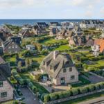 Dorf mit strohgedeckten Häusern und Blick auf das Meer.