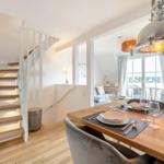 Dining area with table, chairs, and stone staircase to upper level.