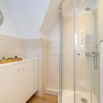 Bathroom with shower, sink, and wall decoration.