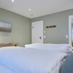 Zimmer mit zwei Betten, Fernseher und Blick in das Badezimmer.