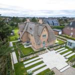 Haus mit Strohdach, gepflasterter Hof und Garten