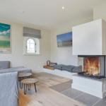 Wohnzimmer mit Kamin, Sofa und Fenster