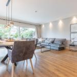 Großer Wohn- und Essbereich mit Sofa, Esstisch und Kamin.